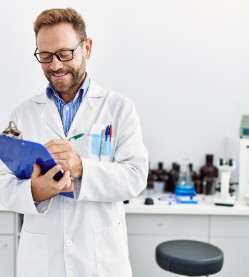 Middle age hispanic man smiling confident wearing scientist uniform at laboratory